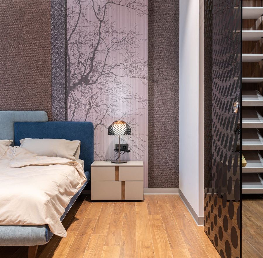 Bedroom with a delicate branch-pattern wallpaper in muted tones