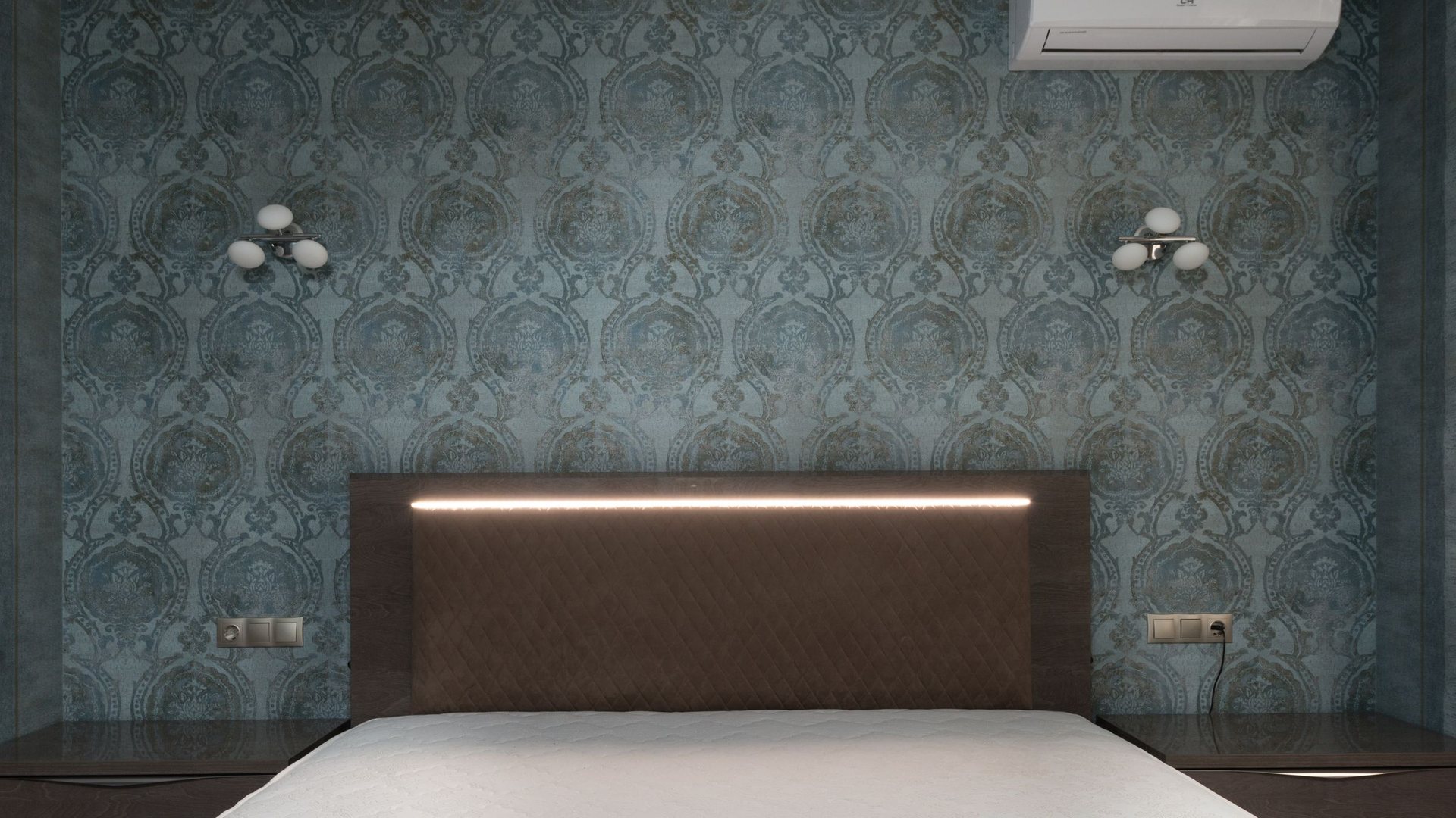 Bedroom with a deep teal damask wallpaper feature wall, upholstered headboard and wall sconces